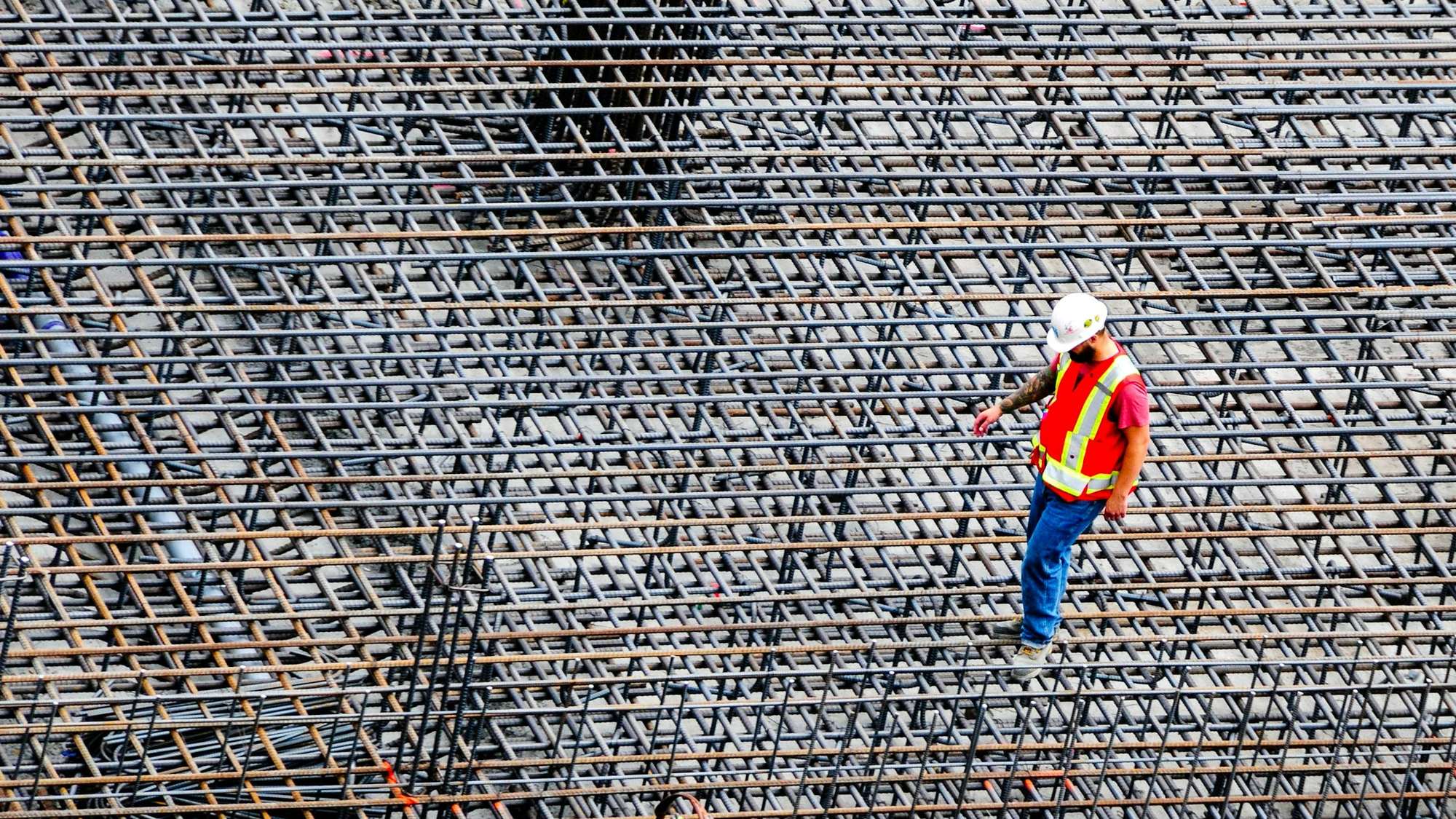 Betonarme temel donatısını kontrol eden şantiye çalışanı
